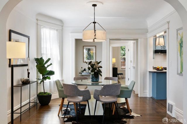 a dining room with furniture potted plants and wooden floor