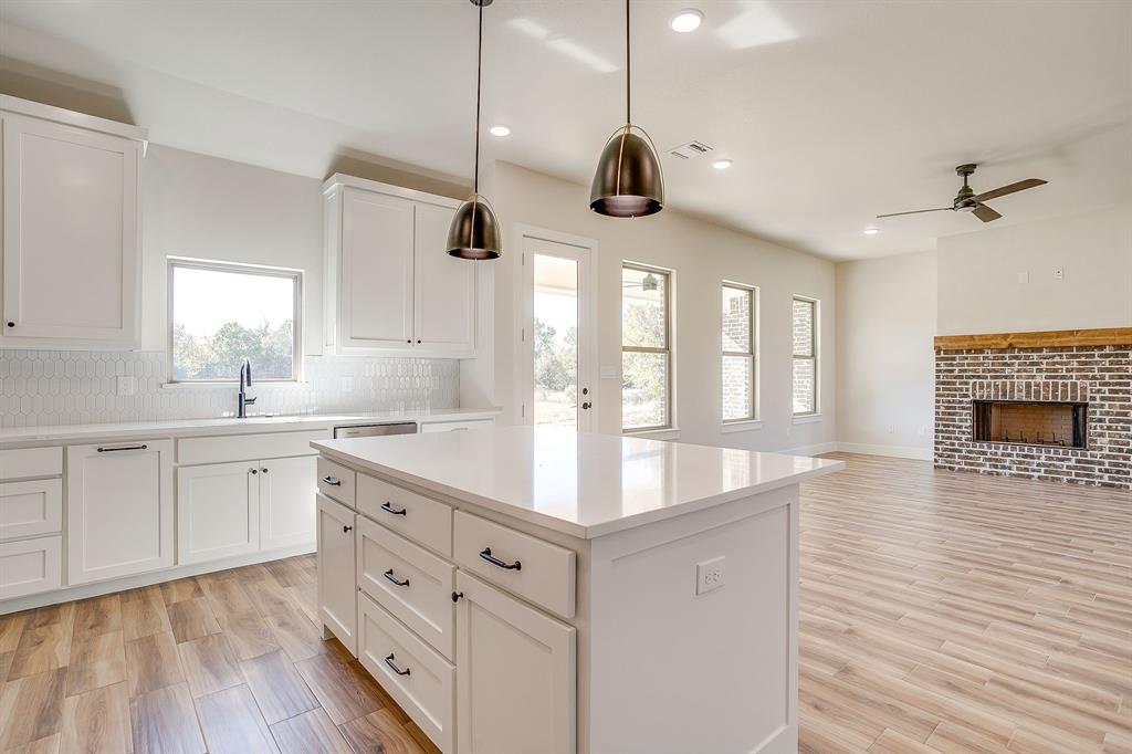 217 Kilkenny Road Poolville, TX 76487 - Photo 13 of 40 a large kitchen with stainless steel appliances a large center island with wooden floor