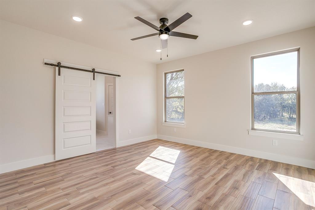 217 Kilkenny Road Poolville, TX 76487 - Photo 19 of 40 a view of empty room with wooden floor and fan