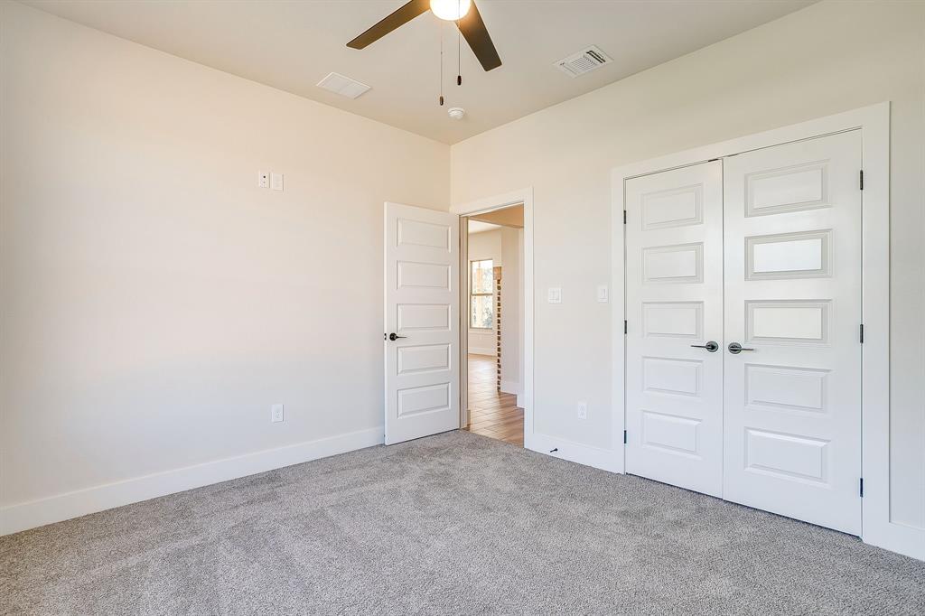 217 Kilkenny Road Poolville, TX 76487 - Photo 29 of 40 an empty room with closet and a ceiling fan