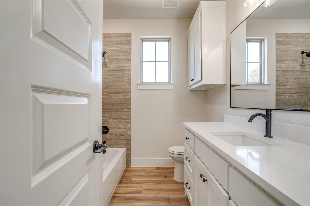 217 Kilkenny Road Poolville, TX 76487 - Photo 30 of 40 a spacious bathroom with a double vanity sink a mirror and a bathtub