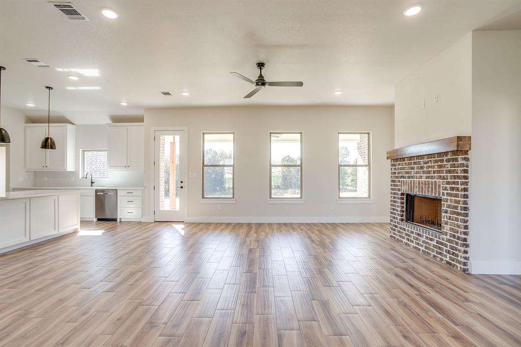 217 Kilkenny Road Poolville, TX 76487 - Photo 5 of 40 a view of an empty room with a kitchen and a fireplace