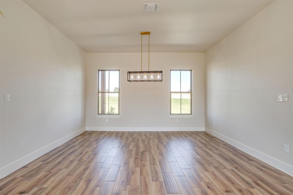217 Kilkenny Road Poolville, TX 76487 - Photo 6 of 40 a view of an empty room with wooden floor and a window