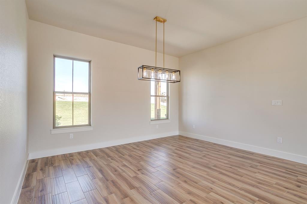 217 Kilkenny Road Poolville, TX 76487 - Photo 9 of 40 a view of empty room with wooden floor and fan