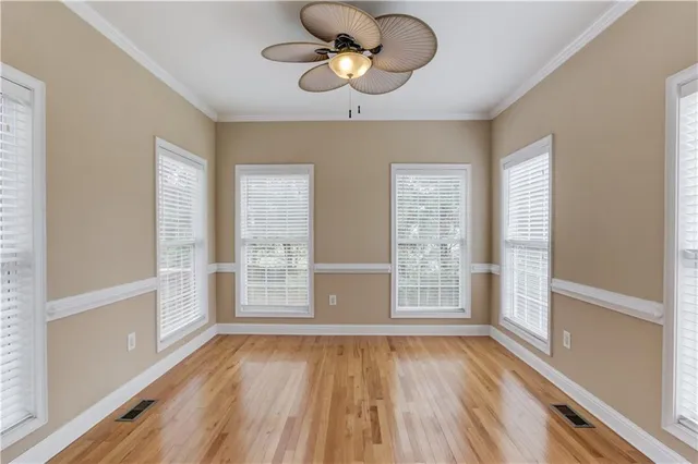 a view of an empty room with a window and wooden floor