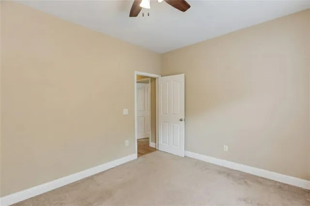 a view of an empty room and chandelier fan