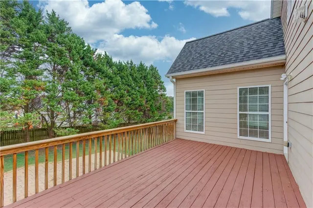 a view of deck with wooden floor and fence next to a yard