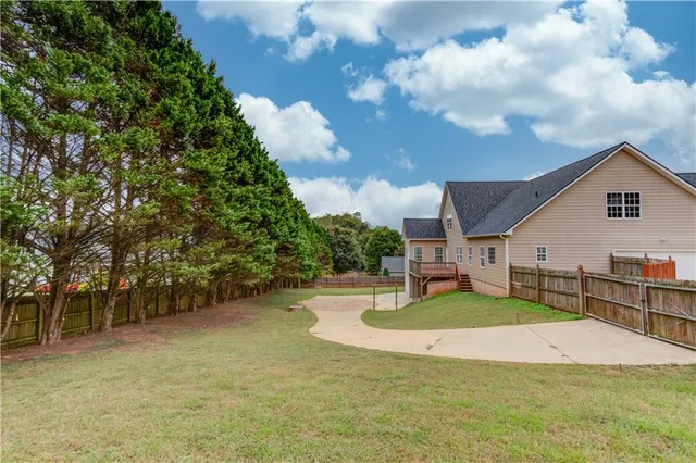 a view of a house with a yard and large tree