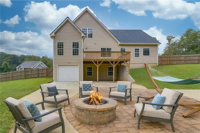 a view of a house with backyard sitting area and swimming pool