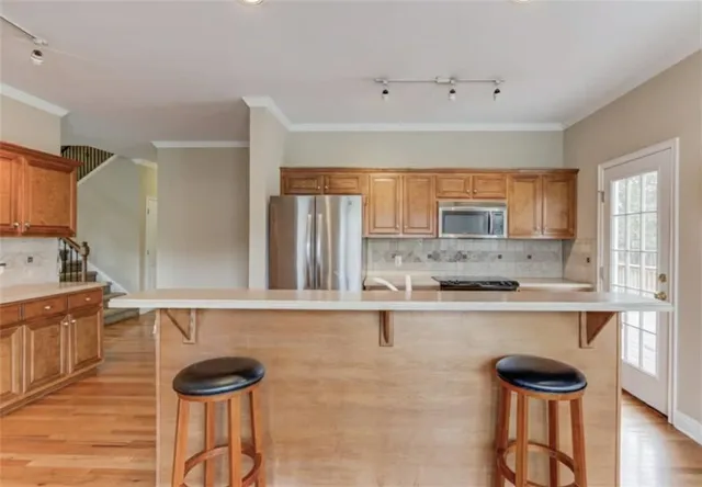 a kitchen with stainless steel appliances granite countertop a stove a sink and a refrigerator