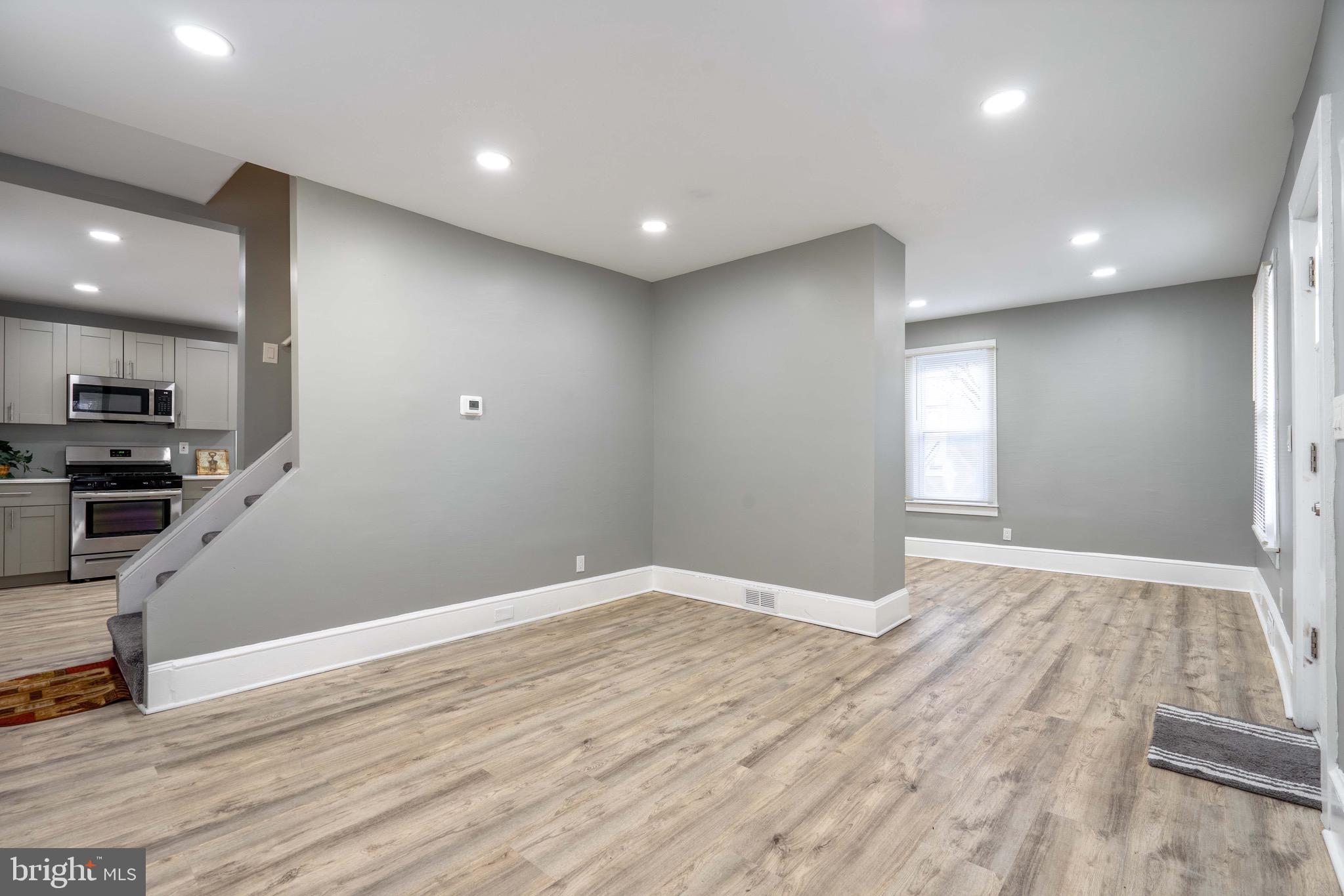 2172 Atco Avenue Atco, NJ 08004 - Photo 8 of 35 an empty room with wooden floor and a kitchen