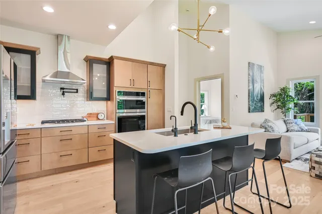 a kitchen with a sink stove and white cabinets with wooden floor