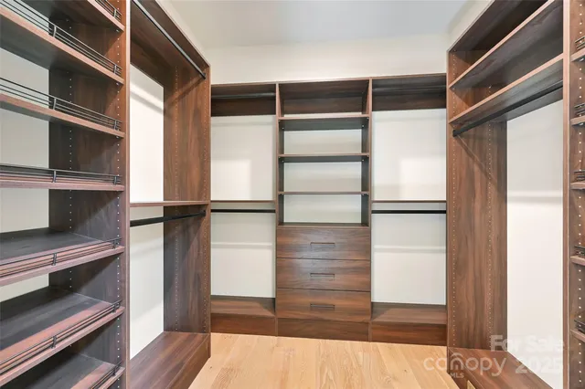 a view of walk in closet with empty racks