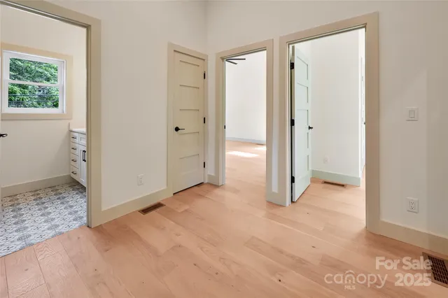 a view of empty room with wooden floor