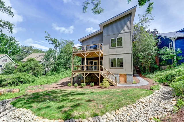 a front view of a house with garden and trees