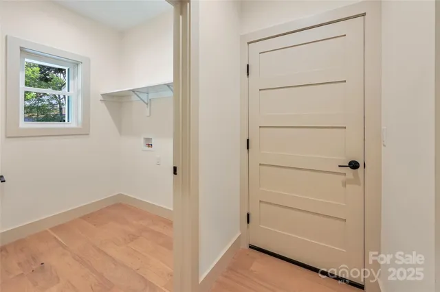 a view of an empty room with closet and a window