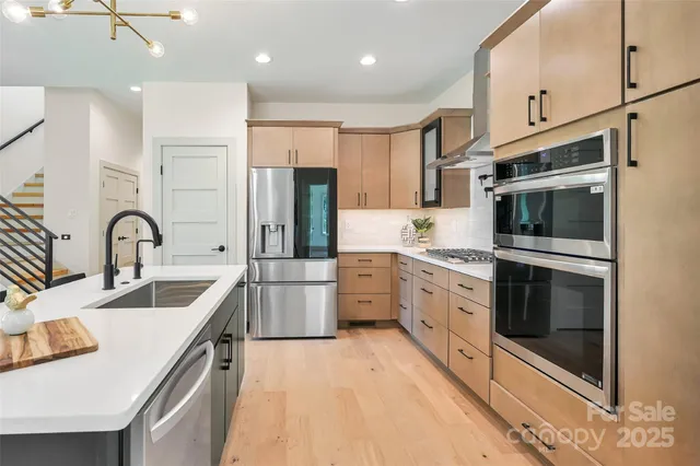 a kitchen with stainless steel appliances granite countertop a sink stove and refrigerator