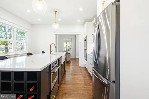 a kitchen with stainless steel appliances kitchen island granite countertop a table chairs and a refrigerator