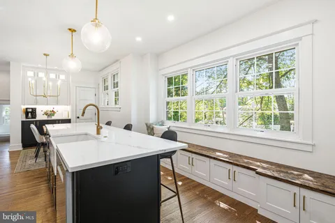 a kitchen with kitchen island a stove a table and chairs in it