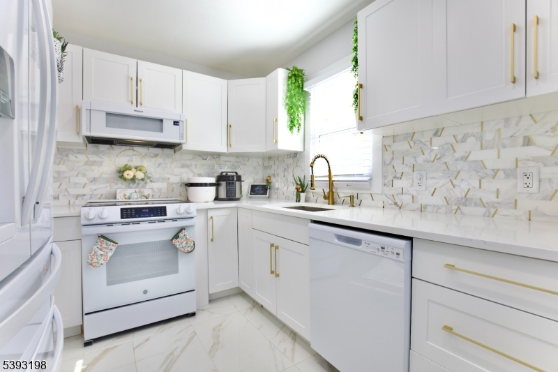 327 Roosevelt Lane Kenilworth, NJ 07033 - Photo 6 of 15 a kitchen with cabinets appliances a sink and a window