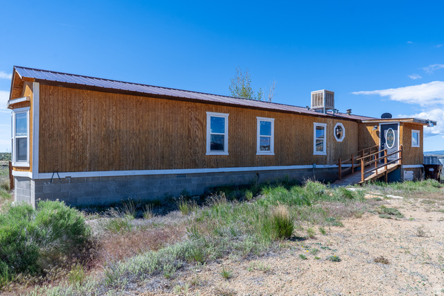 700 East Peter Springs Road Monticello, UT 84535 - Photo 35 of 57 Exterior featuring vertical wood-finish siding, a brown metal roof, and a concrete block perimeter foundation