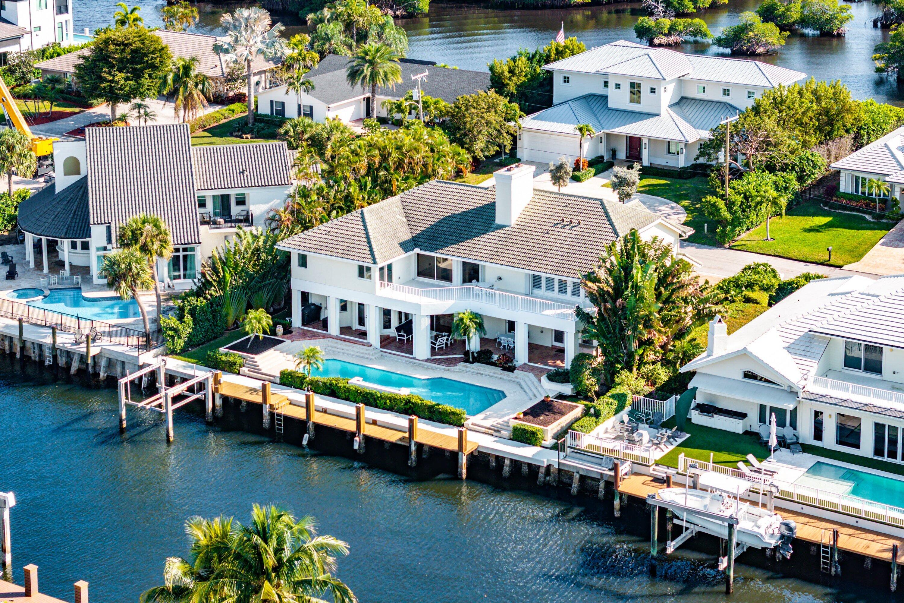 an aerial view of a house with a garden and lake view
