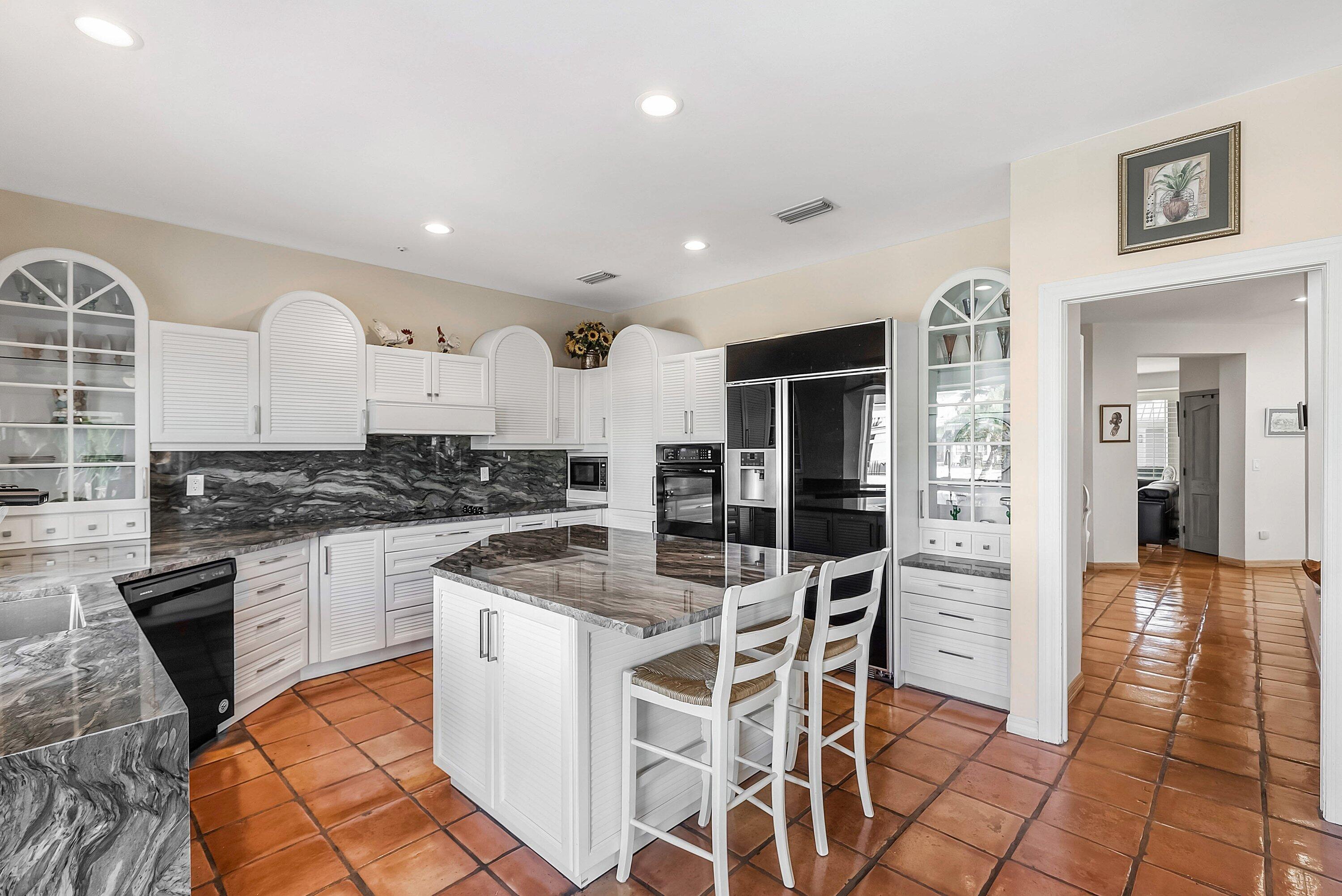 11 Inlet Cay Drive Ocean Ridge, FL 33435 - Photo 14 of 47 a kitchen with stainless steel appliances granite countertop a stove top oven a sink a dining table and chairs