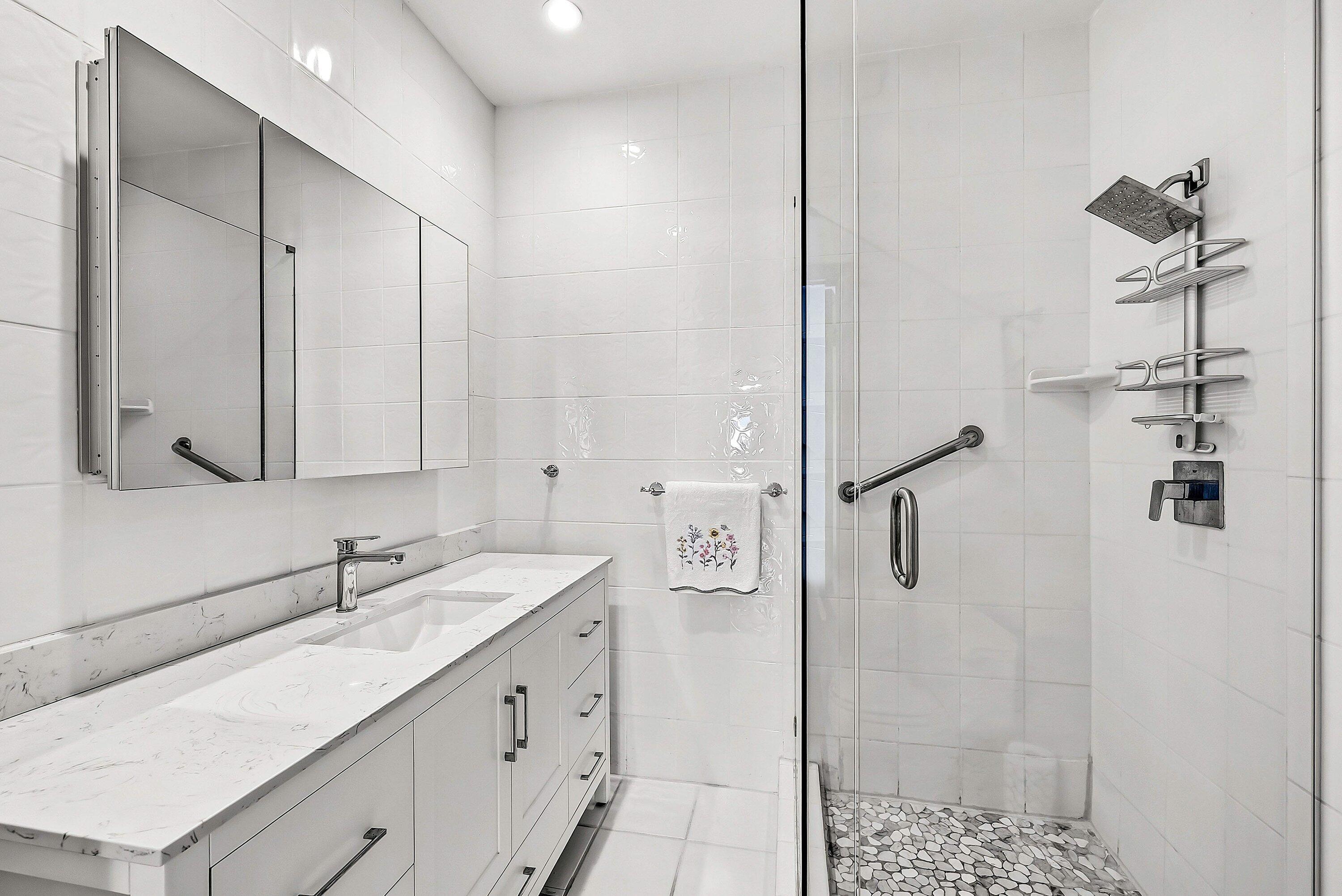 11 Inlet Cay Drive Ocean Ridge, FL 33435 - Photo 21 of 47 a bathroom with a shower sink and mirror