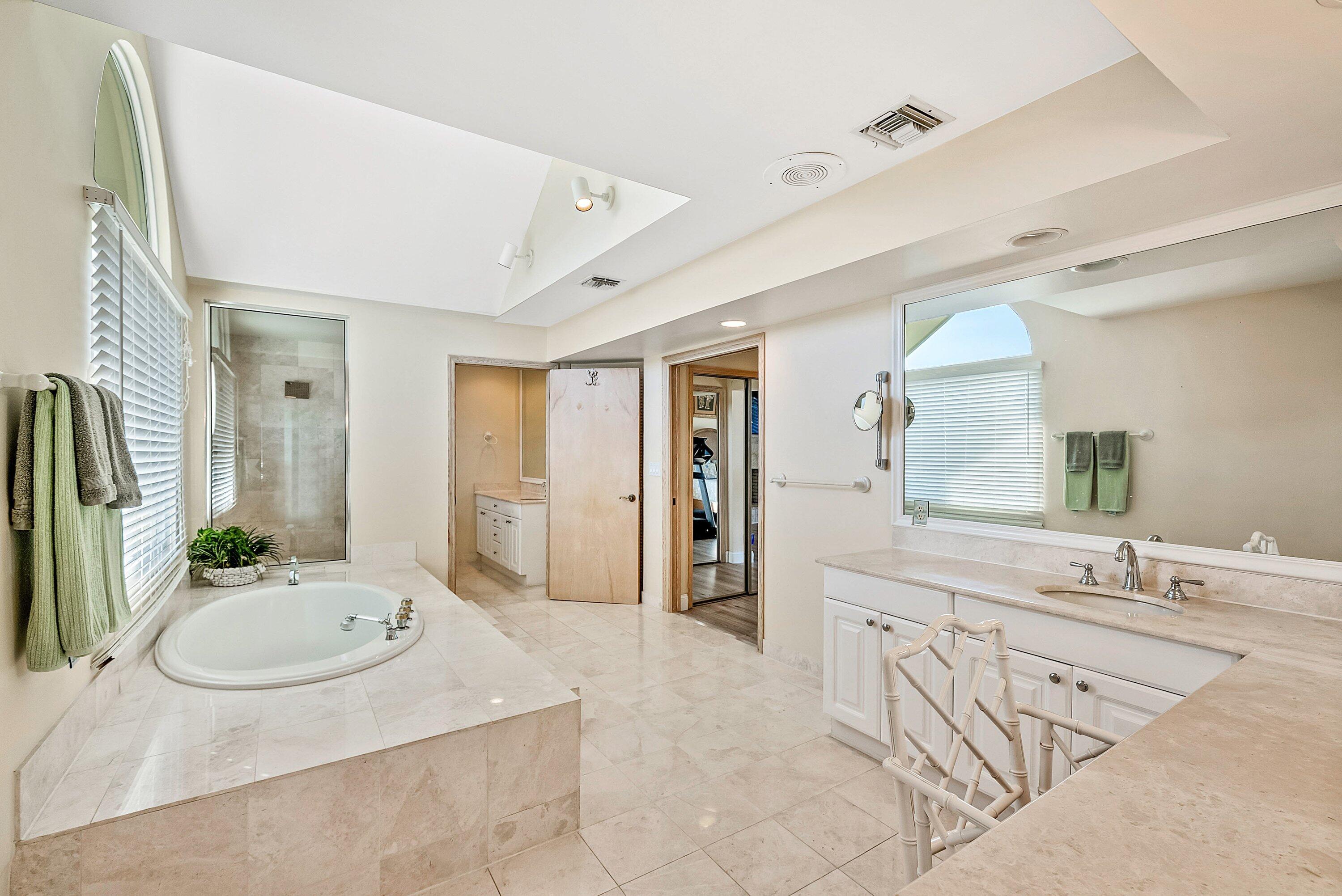 11 Inlet Cay Drive Ocean Ridge, FL 33435 - Photo 26 of 47 a spacious bathroom with a granite countertop sink a mirror and a bathtub