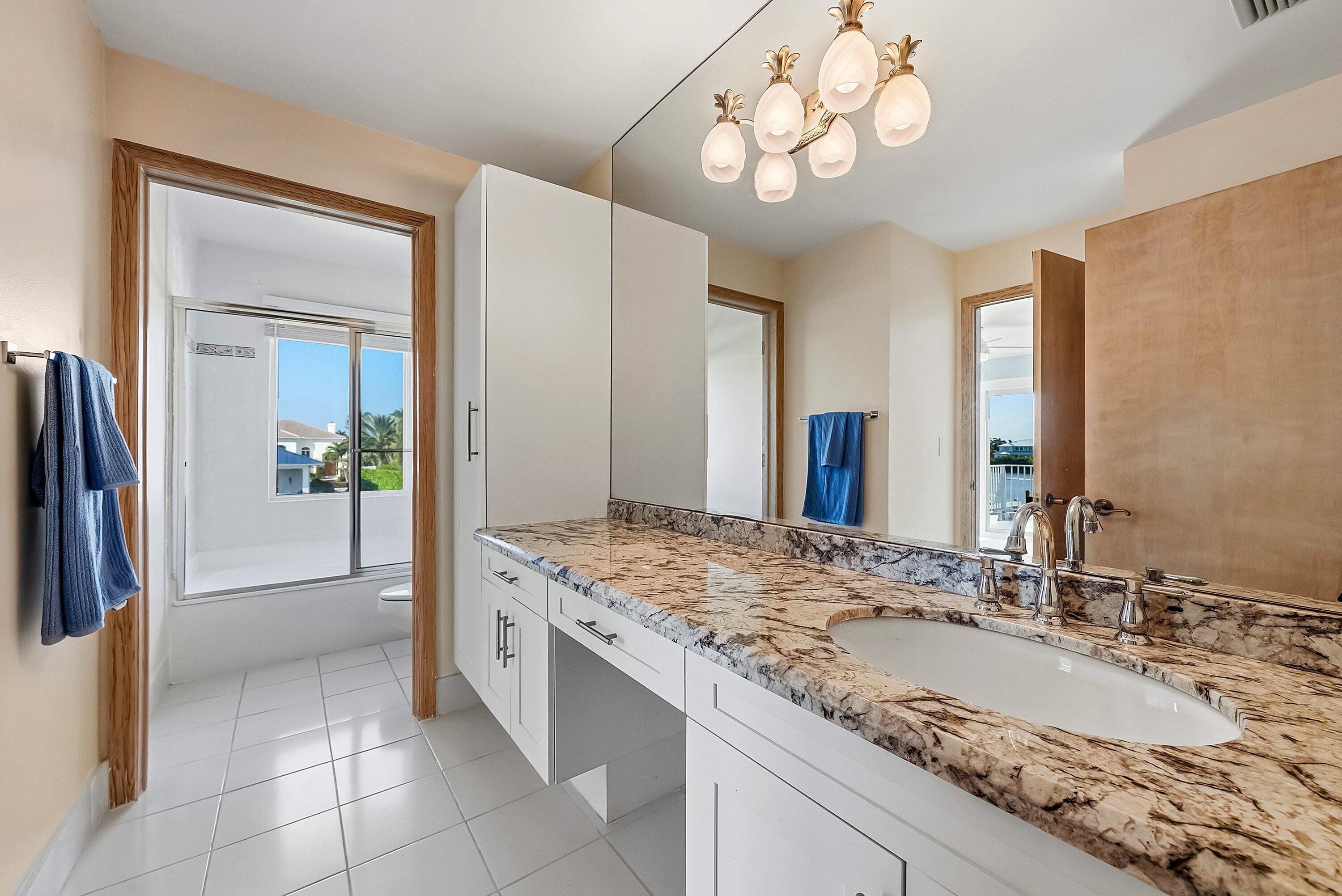 11 Inlet Cay Drive Ocean Ridge, FL 33435 - Photo 31 of 47 a bathroom with a granite countertop sink a large mirror and a shower