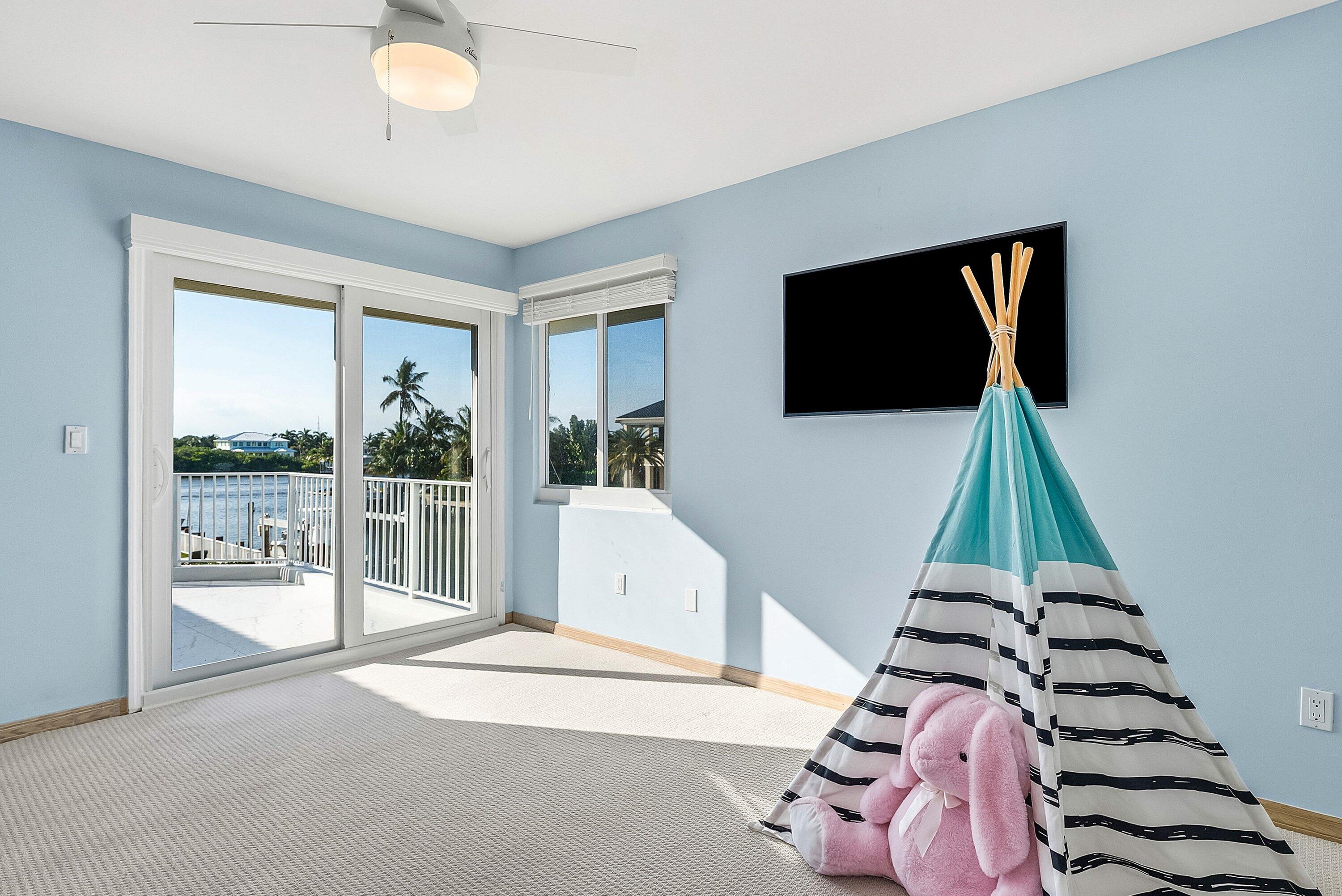 11 Inlet Cay Drive Ocean Ridge, FL 33435 - Photo 33 of 47 a living room with a floor to ceiling window and a flat screen tv