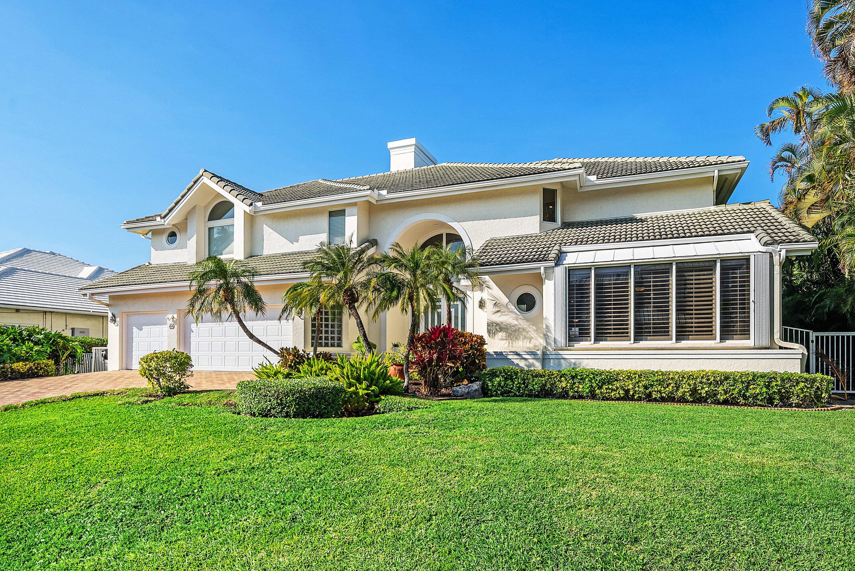 11 Inlet Cay Drive Ocean Ridge, FL 33435 - Photo 5 of 47 a front view of a house with a garden and plants