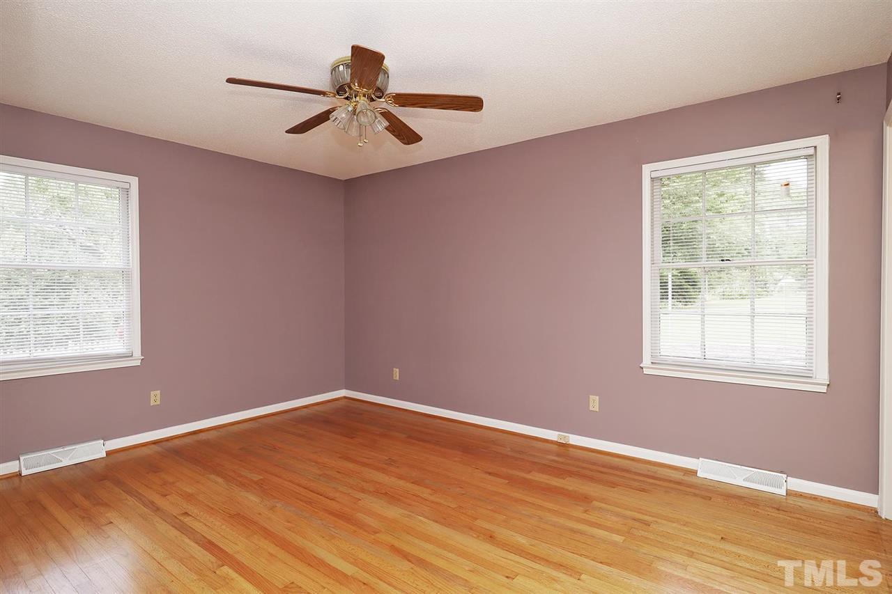 5027 Winterlochen Road Raleigh, NC 27603 - Photo 12 of 25 a view of an empty room with wooden floor and a window