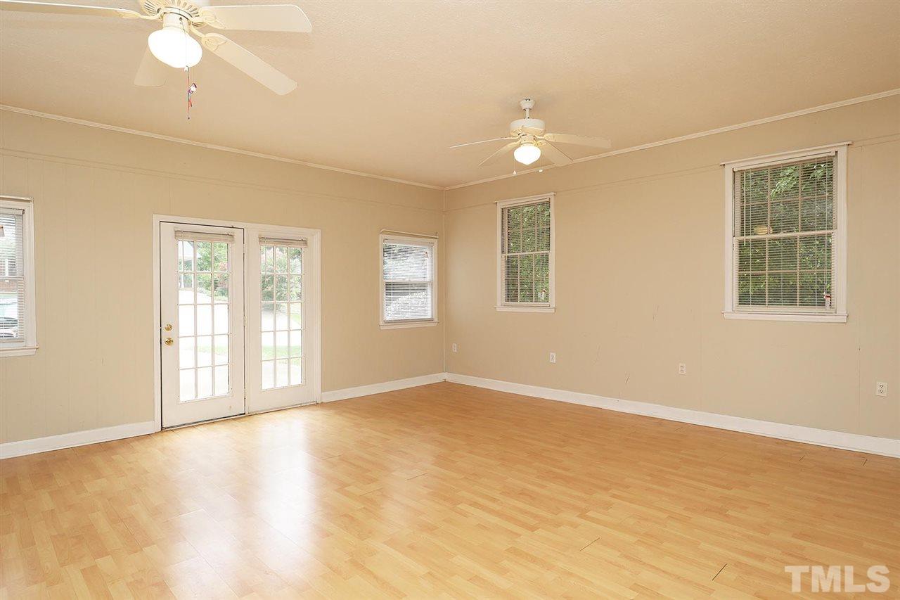 5027 Winterlochen Road Raleigh, NC 27603 - Photo 8 of 25 a view of an empty room with a window and wooden floor