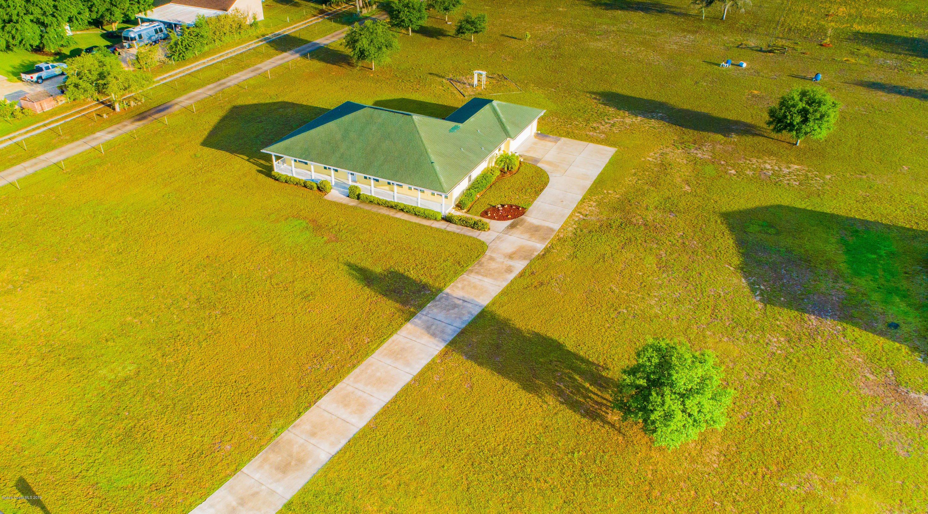 3700 Grant Line Road Mims, FL 32754 - Photo 3 of 40 a blue swimming pool with lawn chairs under an umbrella
