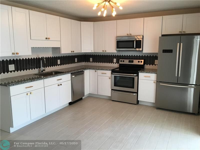 Brand new custom kitchen. All new appliances with counter depth refrigerator. Large single bowl sink, granite counter tops, bras handles and bras sputnik light fixture.