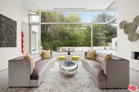 a living room with patio furniture and a potted plant
