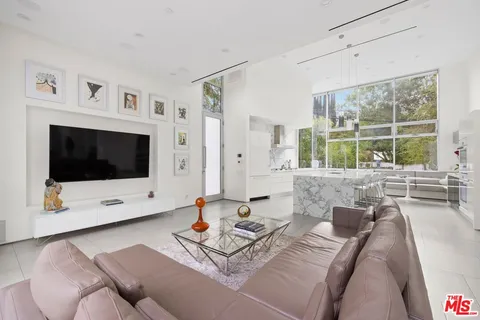 a living room with furniture a flat screen tv and a large window