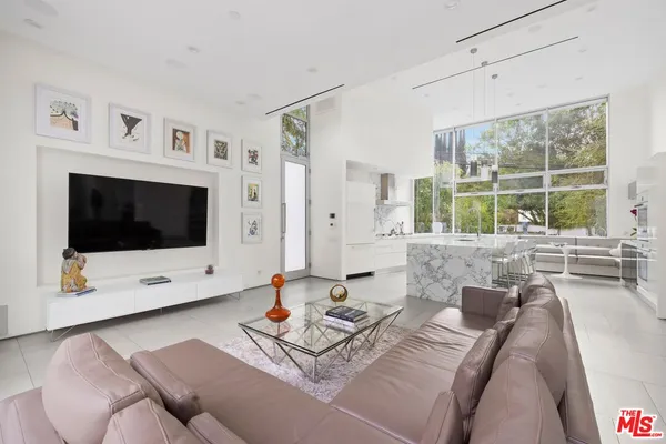 a living room with furniture a flat screen tv and a large window