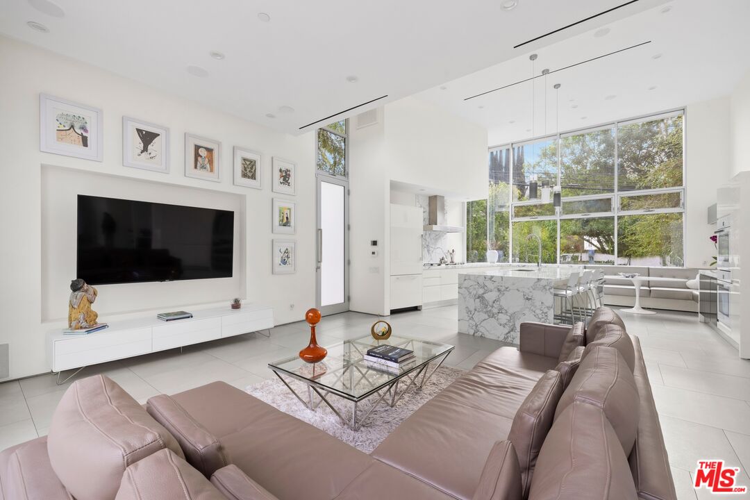 2654 Roscomare Road Los Angeles, CA 90077 - Photo 6 of 29 a living room with furniture a flat screen tv and a large window