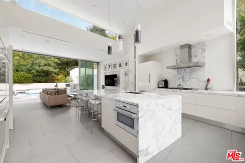 a kitchen with stainless steel appliances kitchen island granite countertop a sink and white cabinets