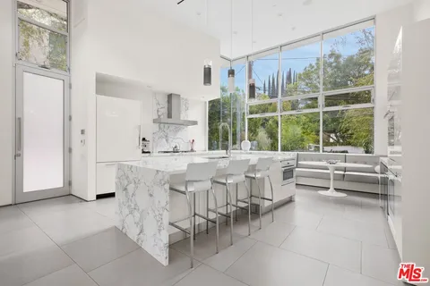 a dining hall with stainless steel appliances kitchen island granite countertop a table and chairs