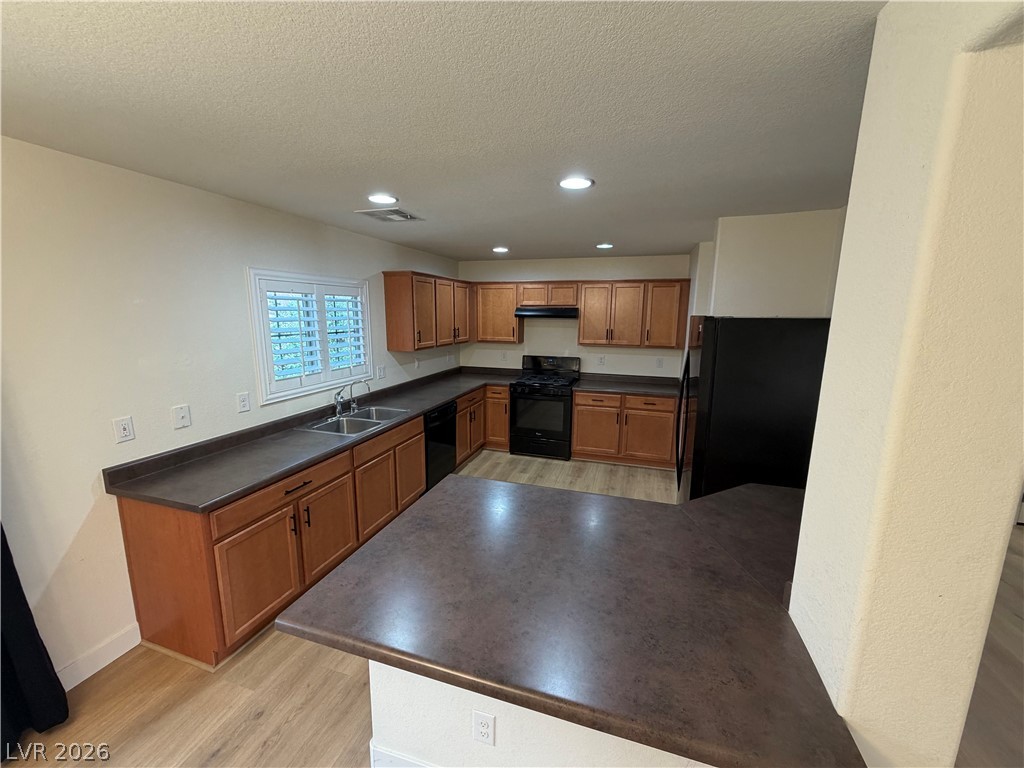 7879 Shoreline Ridge Court Las Vegas, NV 89166 - Photo 6 of 26 Warm wood cabinetry and dark countertops define this classic kitchen layout.