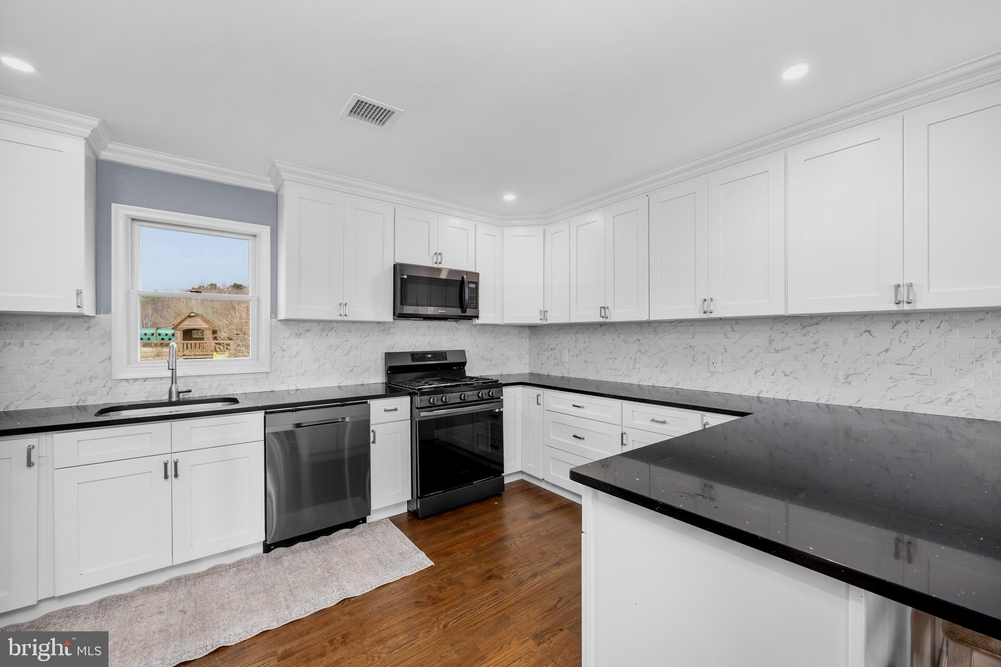 14470 Backbone Road Eden, MD 21822 - Photo 7 of 55 a kitchen with stainless steel appliances granite countertop a sink dishwasher stove and white cabinets with wooden floor