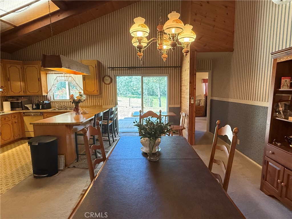 4952 Hidden Springs Road Mariposa, CA 95338 - Photo 20 of 53 a dining hall with furniture a chandelier a large window and wooden floor