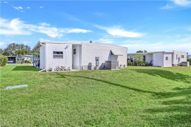 a view of a house with a big yard and large trees