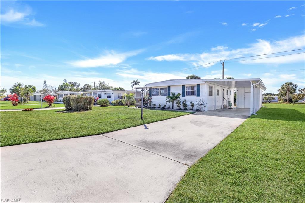 21 Lemans Drive Naples, FL 34112 - Photo 3 of 26 a view of a house with a big yard and potted plants