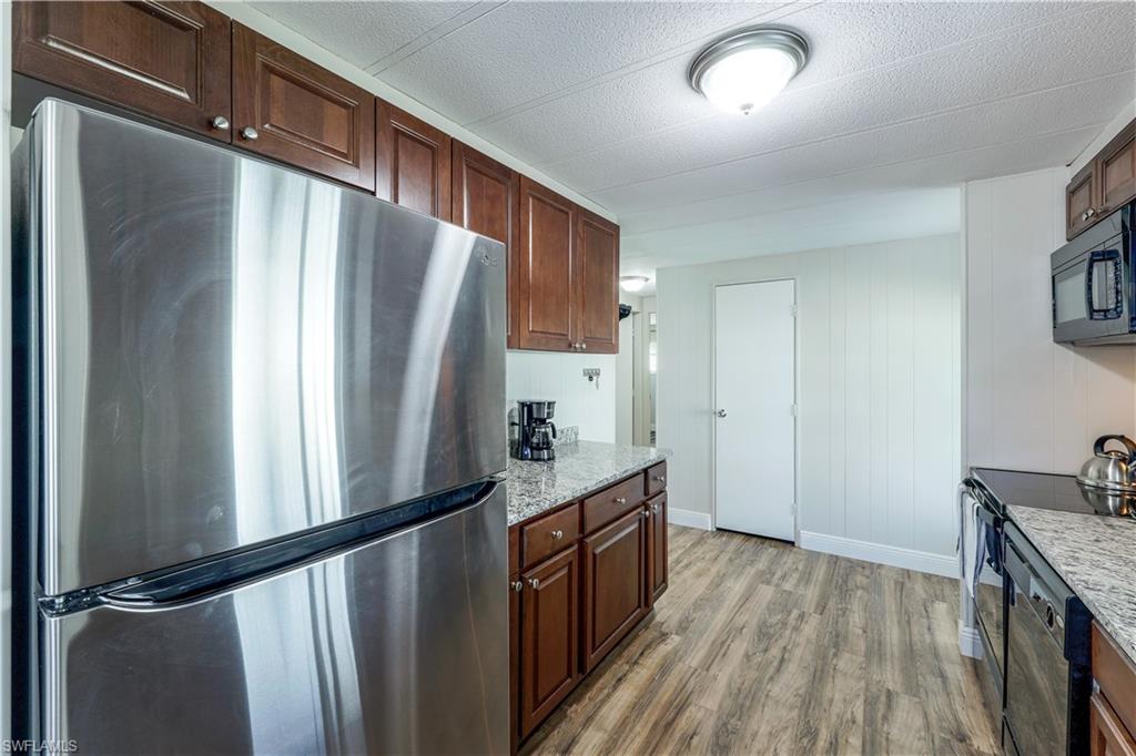 21 Lemans Drive Naples, FL 34112 - Photo 10 of 26 a kitchen with stainless steel appliances granite countertop a refrigerator a stove and a wooden floors