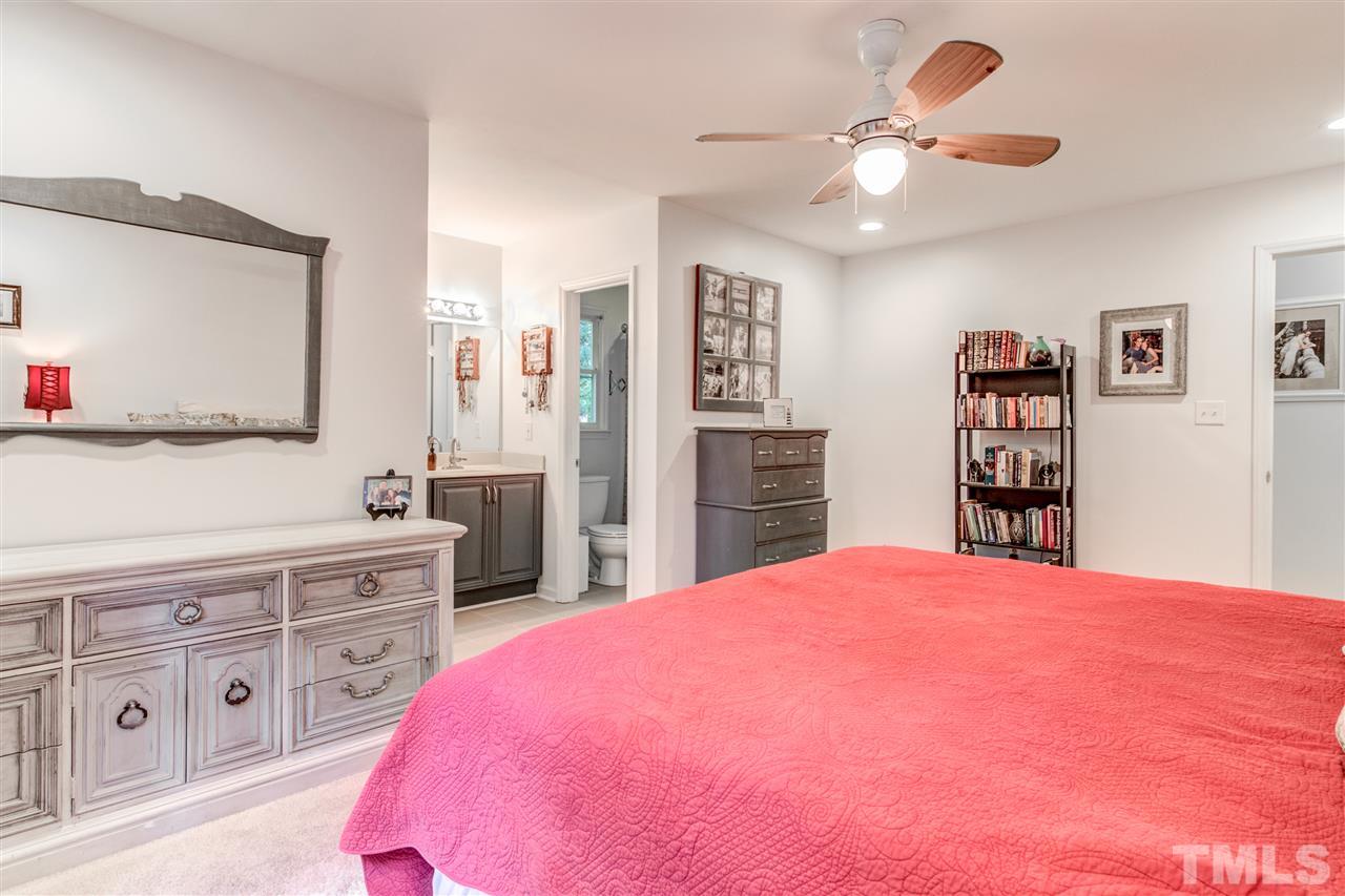 2724 Quail Point Drive Raleigh, NC 27603 - Photo 15 of 25 a spacious bedroom with a bed a dresser and a book shelf