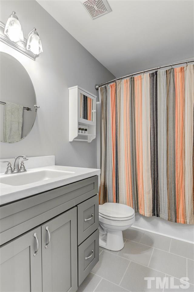 2724 Quail Point Drive Raleigh, NC 27603 - Photo 21 of 25 a bathroom with a sink a toilet and a mirror